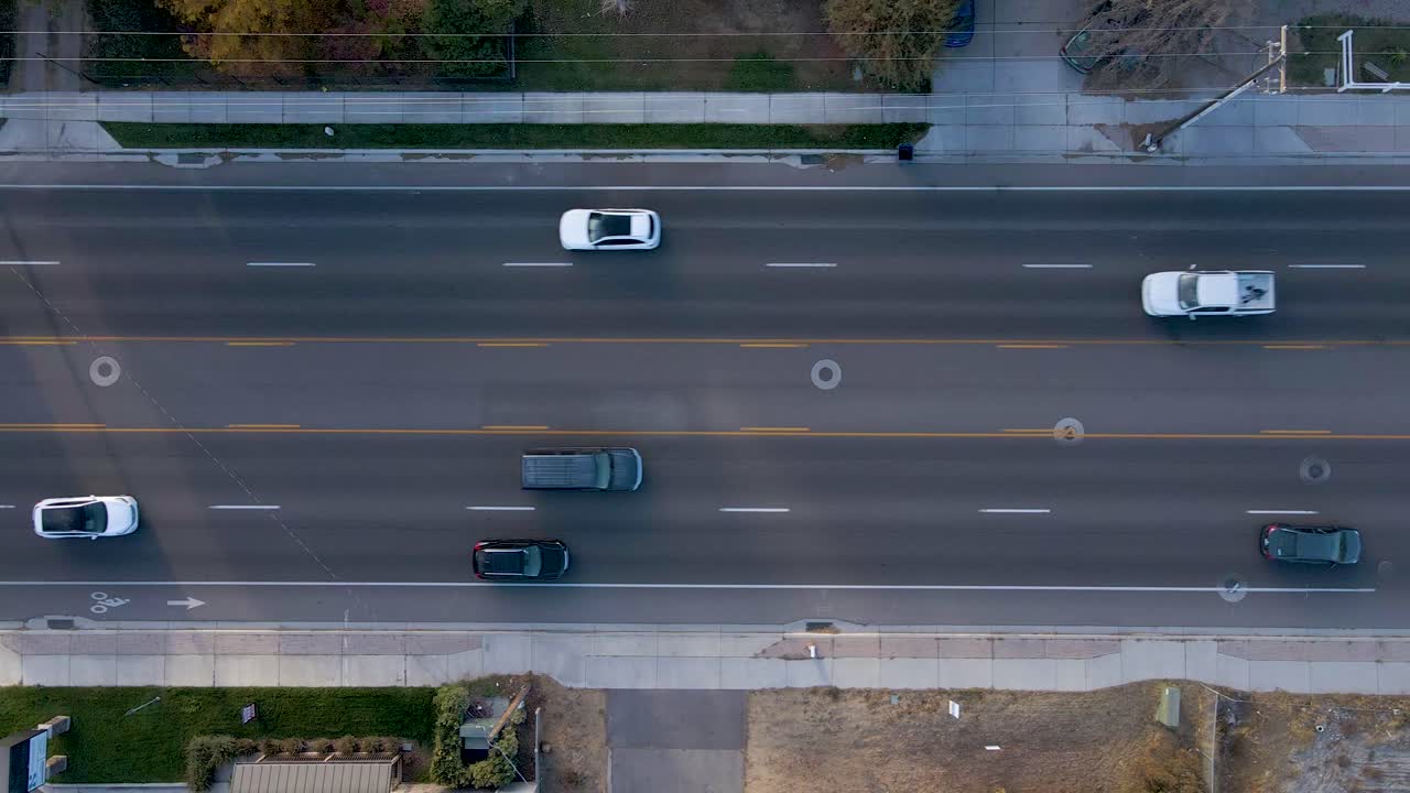 유타 주 유타 카운티의 쾌적한 숲에 있는 고급 주거 지역 근처의 도로를 가로질러 이동하는 차량