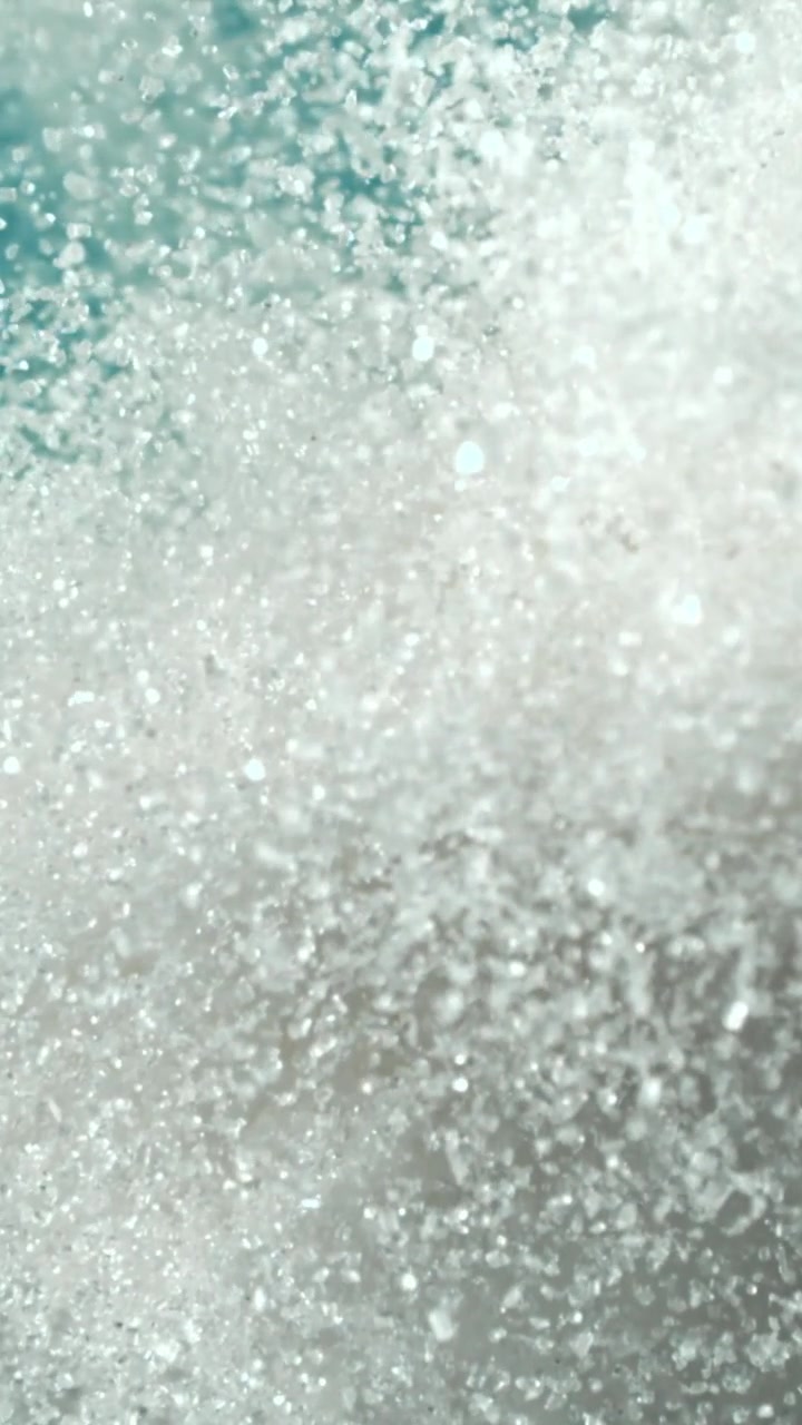 Primo piano macro di cristalli di zucchero bianco con messa a fuoco su sfondo blu