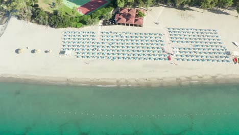 Aerial-view-of-beautiful-sea-and-beach-with-parasol-at-sunny-day,-Simeri-Mare,-Calabria,-Southern-Italy