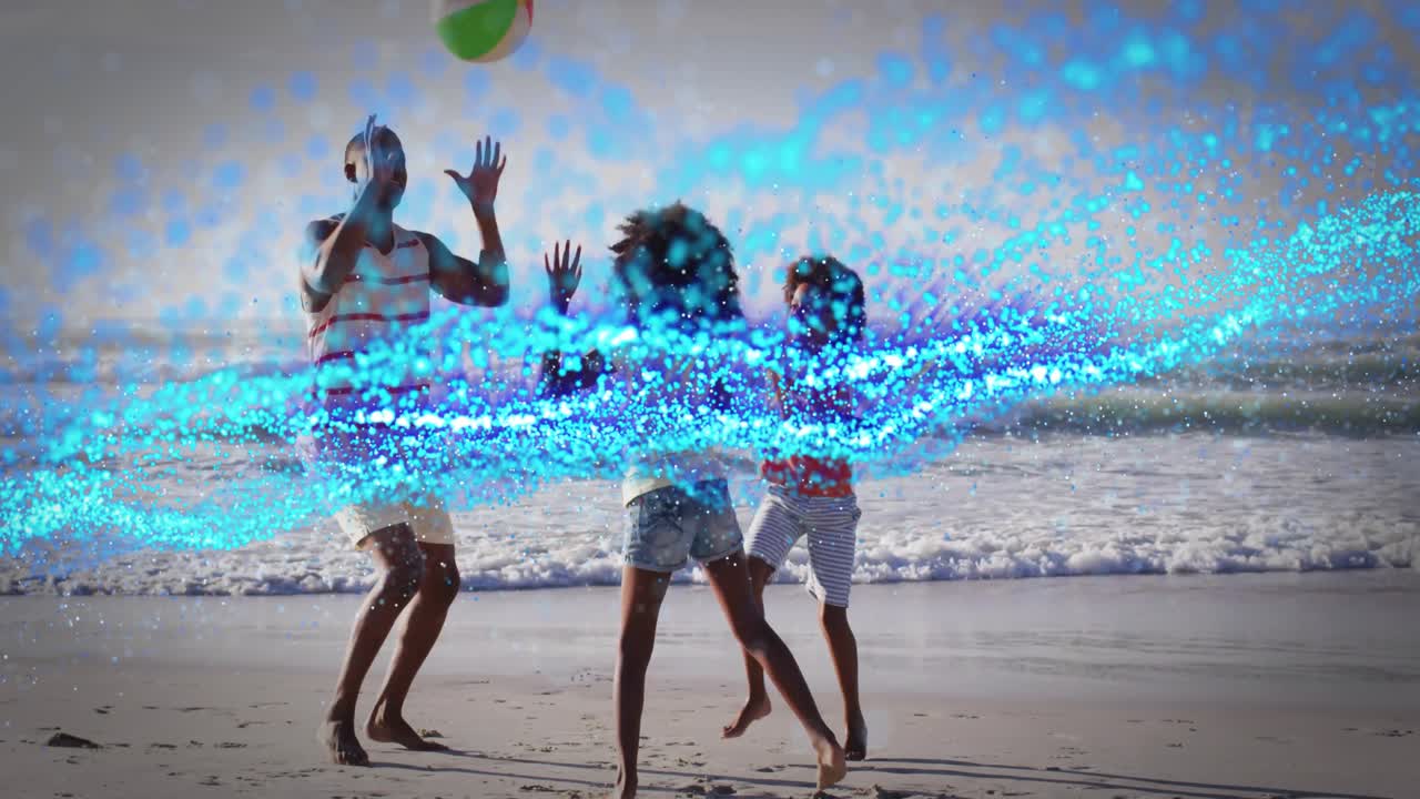 Girl raising beach ball overhead initiating family catching game on wet sand near waves