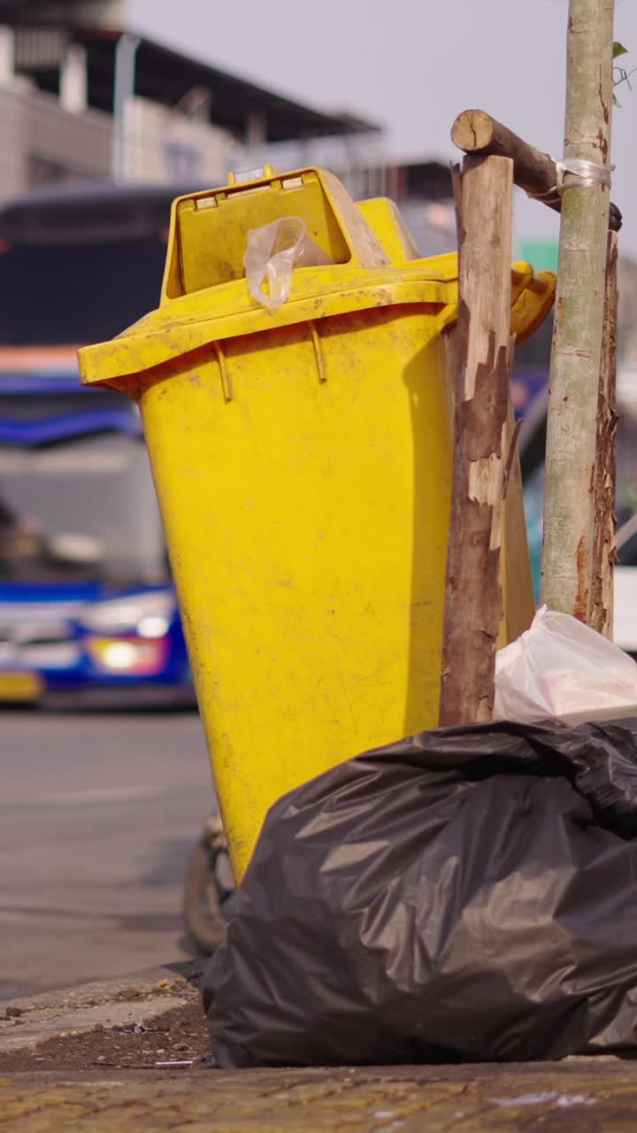 Images of a yellow trash can on the street