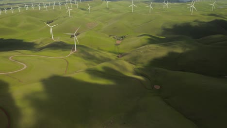 Toma-Aérea-De-Nubes-Rodando-Sobre-Colinas-Verdes-Que-Revelan-Turbinas-Eólicas-En-El-Paso-De-Altamont-En-La-Autopista-Vasco-Road-Con-Colinas-Verdes-En-California