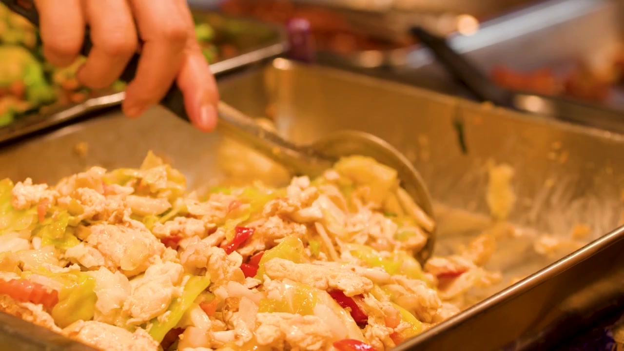 Chef che salta in padella verdure e pollo in una grande padella di metallo.