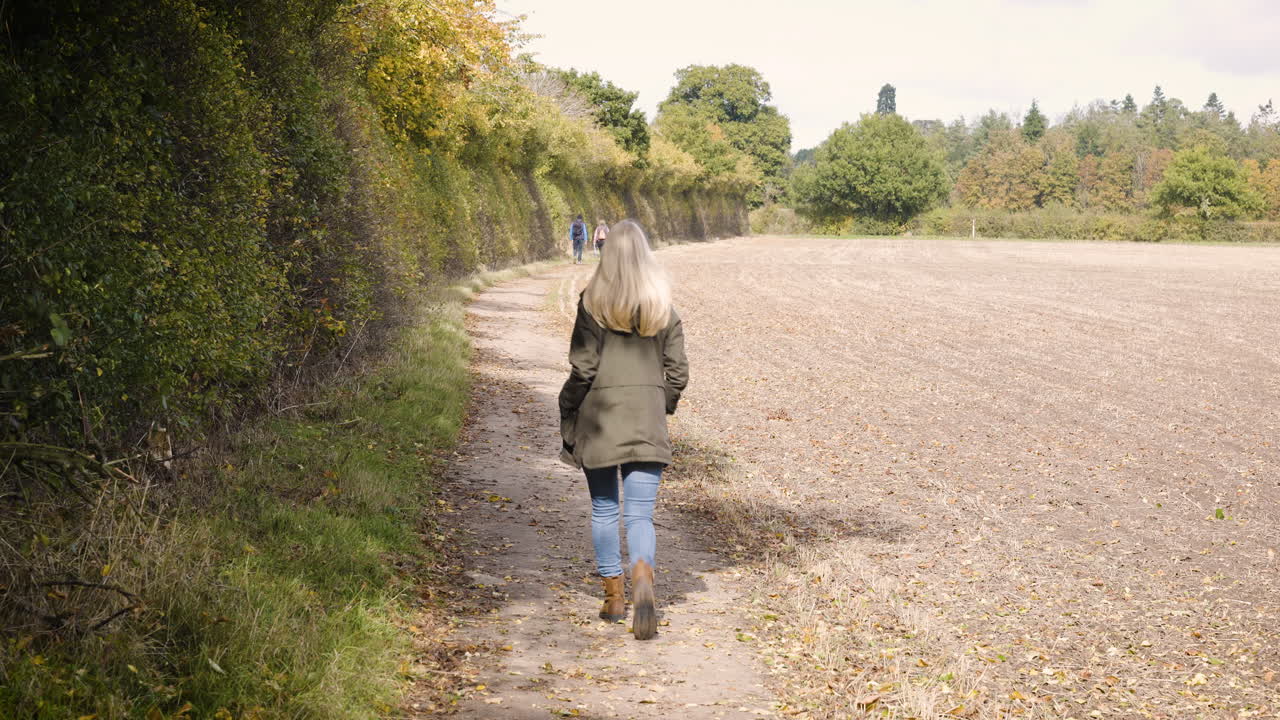 Woman walking on a path through the countryside