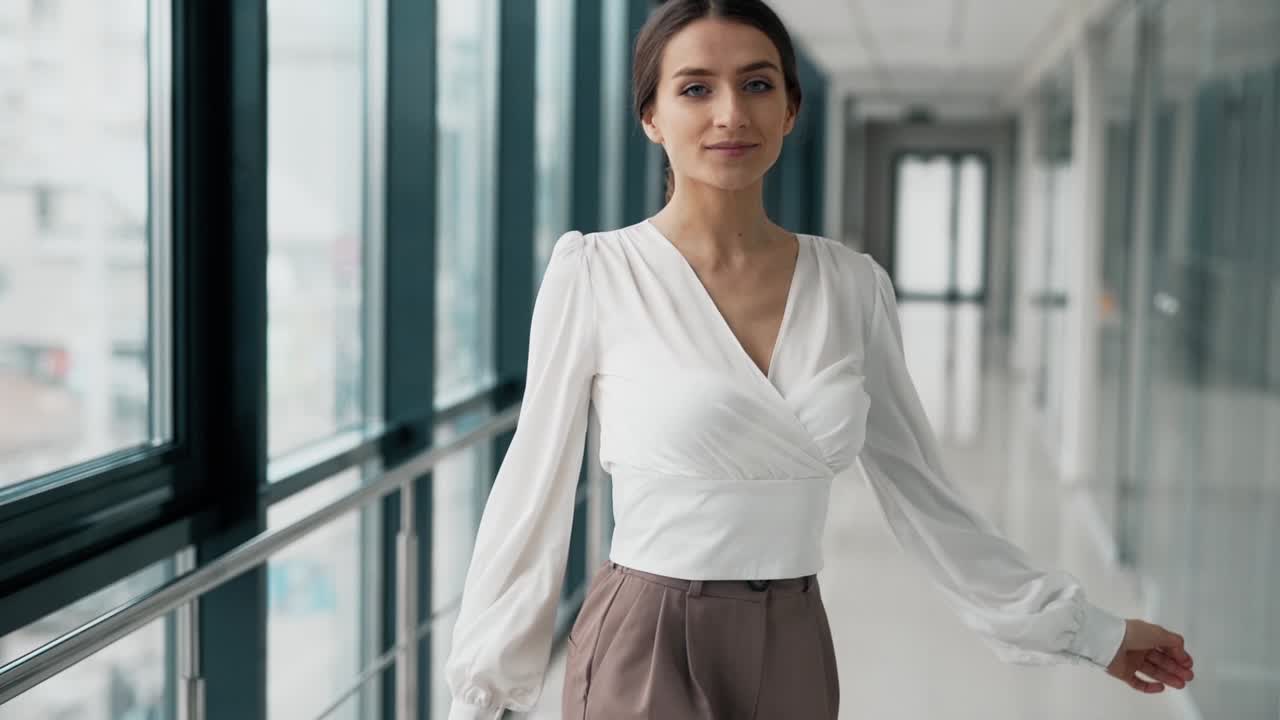Pretty young woman posing beautifully and spinning in a glass corridor