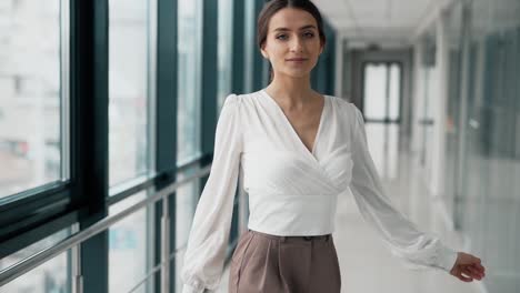 Hübsche-Junge-Frau,-Die-Wunderschön-Posiert-Und-Sich-In-Einem-Glaskorridor-Dreht