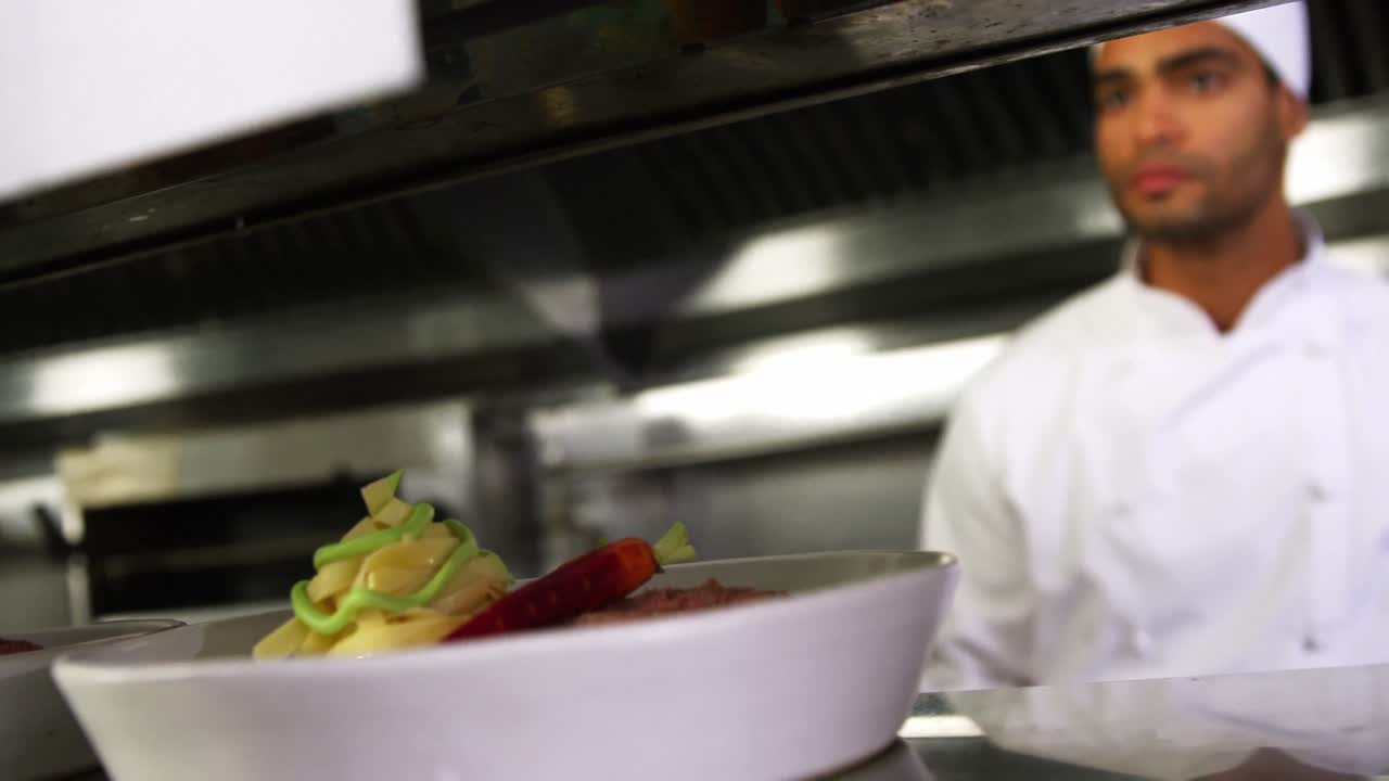 primer plano del chef manteniendo el plato de aperitivos listo en la estación de pedidos