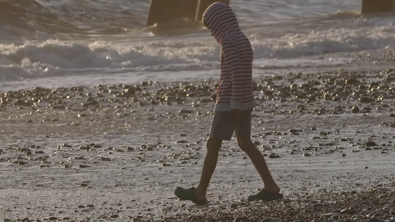 해가 지는 해변에서 고 있는 아이