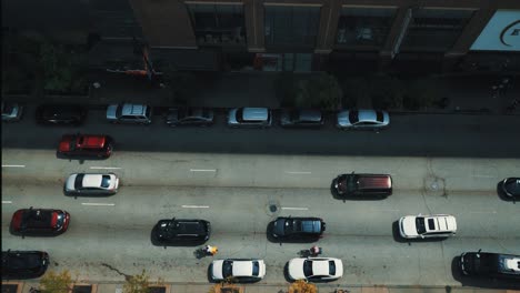 cars move along street in city. rows of street automobiles on road. top view