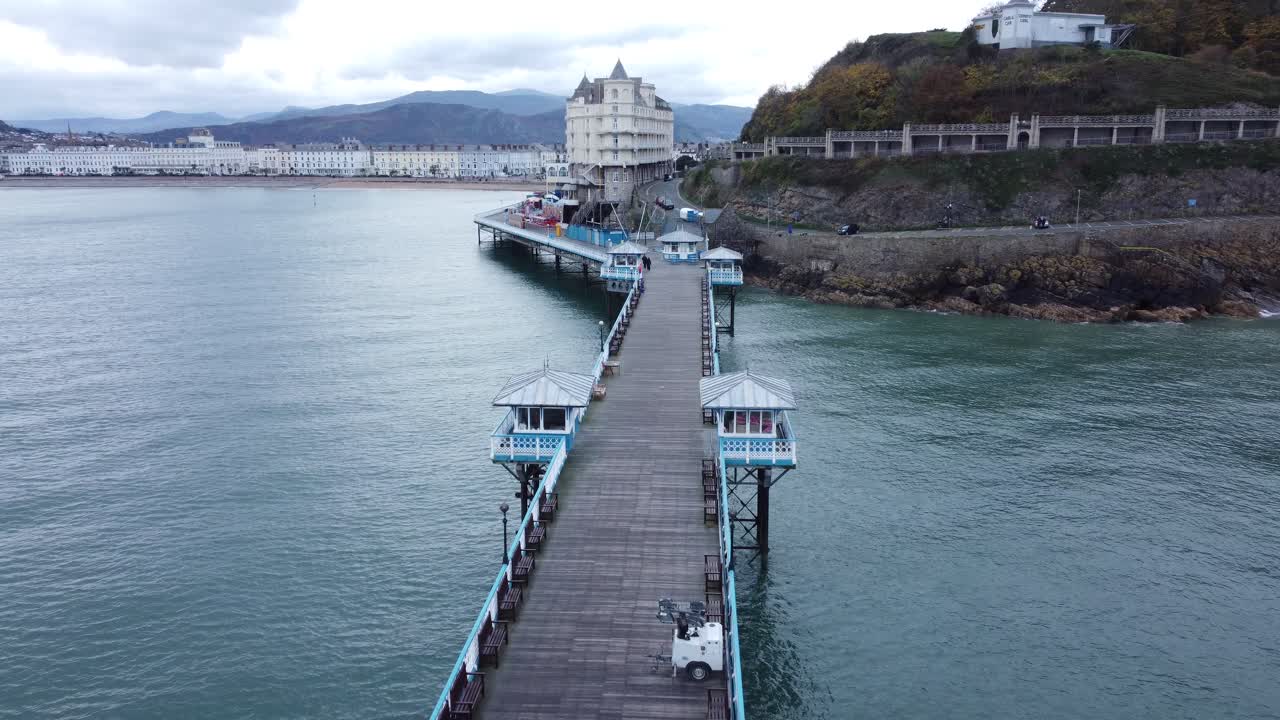 Llandudno pier historic Victorian wooden boardwalk seaside landmark aerial view travelling low overhead