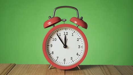 reloj de alarma rojo vintage en una mesa de madera natural que suena a las doce.