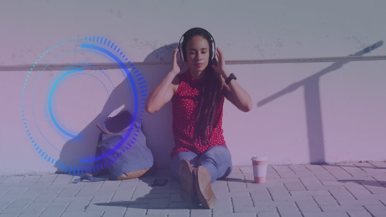 Animation of scope scanning over biracial woman sitting and wearing headphones