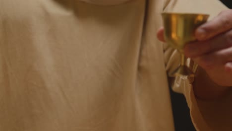 Close-Up-Shot-Of-Man-Wearing-Robes-With-Long-Hair-And-Beard-Representing-Figure-Of-Jesus-Christ-Blessing-Bread-And-Wine-1