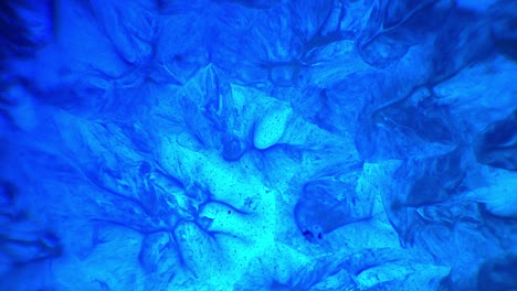 Blue ink and paint liquid reaction abstract texture background