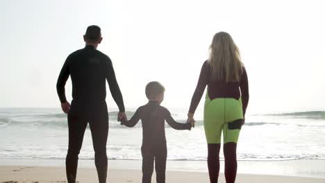 family holding hands and walking on beach