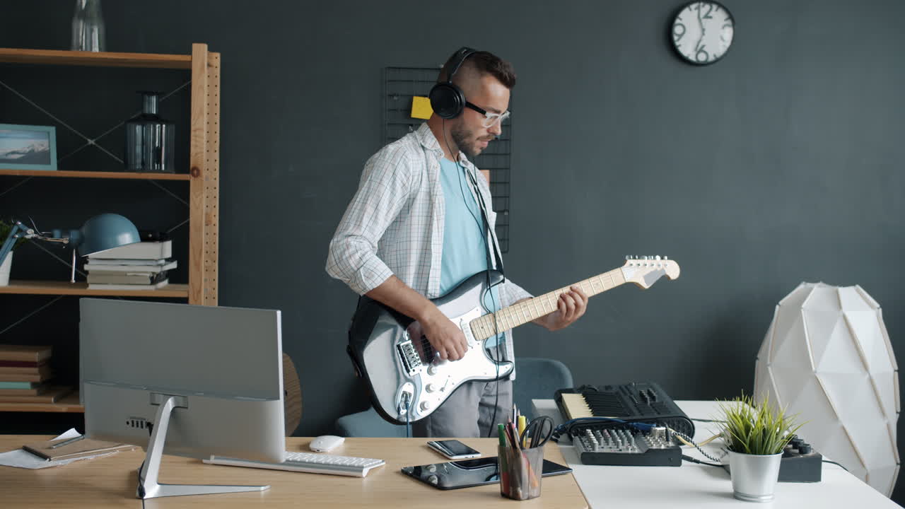 Hombre tocando la guitarra en un estudio casero