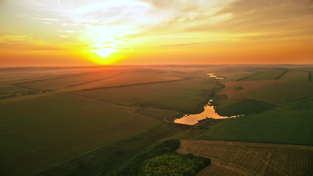 Aerial drone view of nature in Moldova at sunset. Lakes, sun, fields and hills