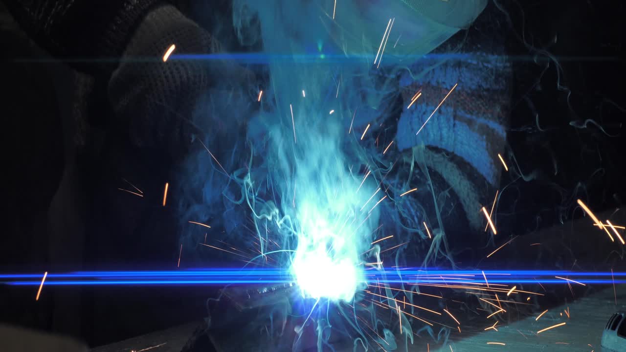 금속 용접공은 보호 장비를 갖춘 공장에서 강철 용접공과 함께 일합니다