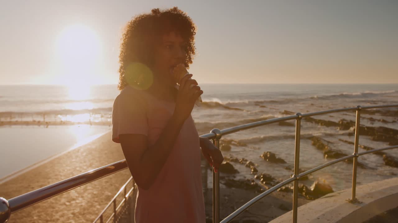Woman eating ice cream at sunset