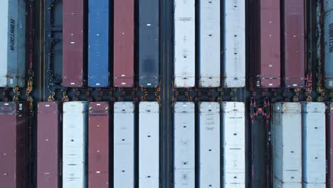 an aerial view of a cargo yard featuring rows of shipping containers in various colors and textures, highlighting the intricacies of freight transportation and logistics