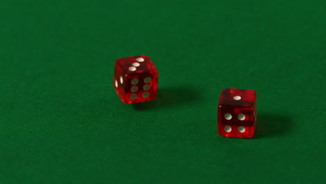 los dados rojos caen en la mesa del casino.