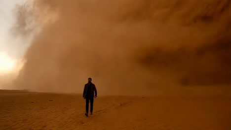 hombre caminando a través de una tormenta de arena en el desierto