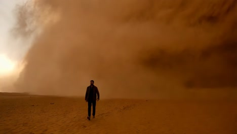 man walking through a sandstorm in the desert