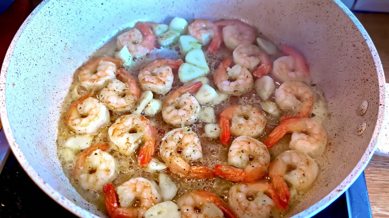 Shrimp and garlic fry in a pan with oil. Close up shot.