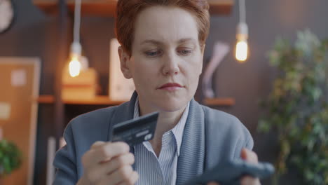 mujer que utiliza teléfono móvil y tarjeta de crédito para el pago en línea
