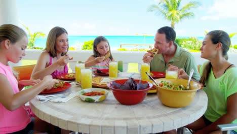 happy young caucasian family eating lunch together outdoors