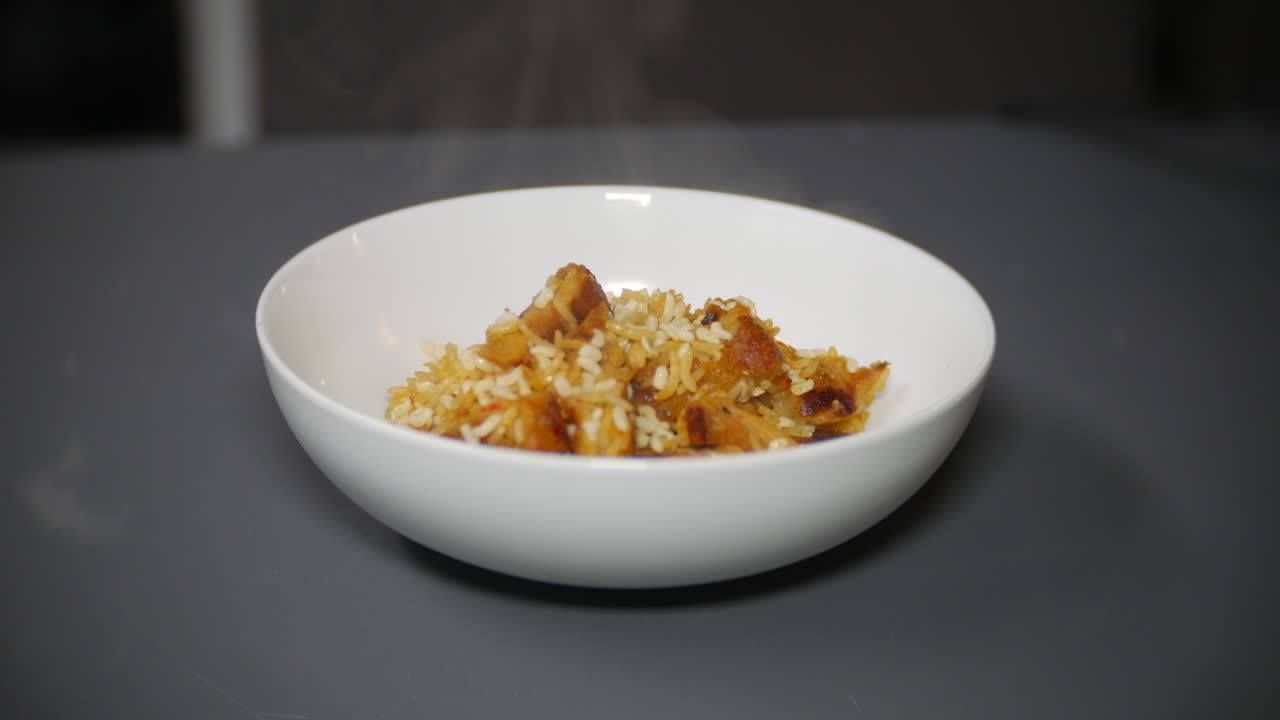 arroz frito con pollo humeante en un tazón en casa