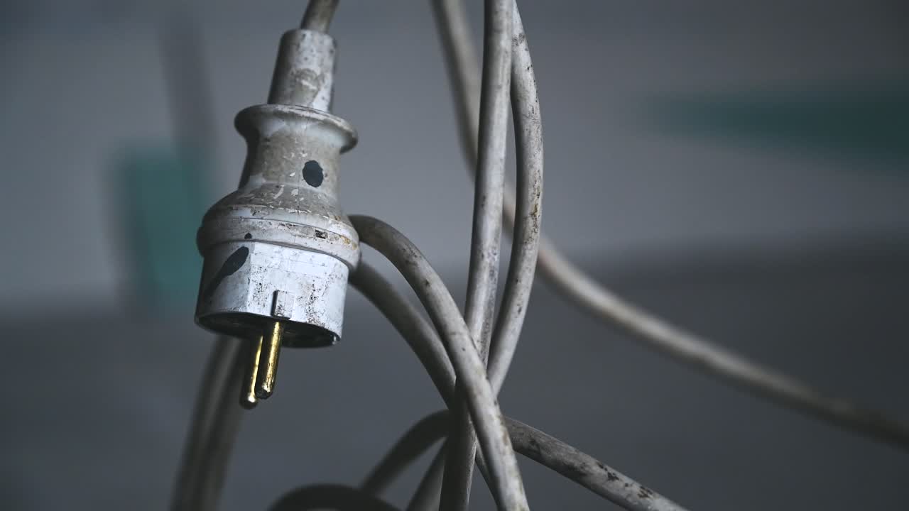 Dirty power plug hanging in a dark interior