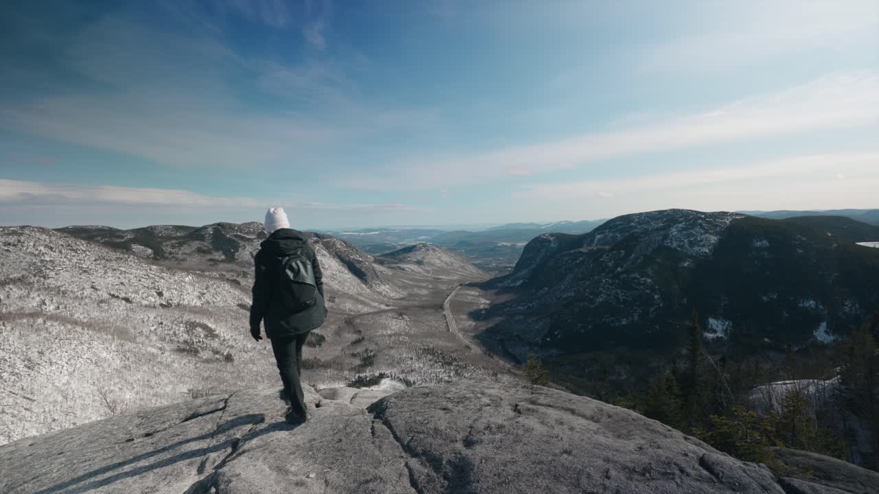 niña caminando en la parte superior con vistas a la montaña mont du dome en quebec, canadá en un día soleado de invierno - plano general