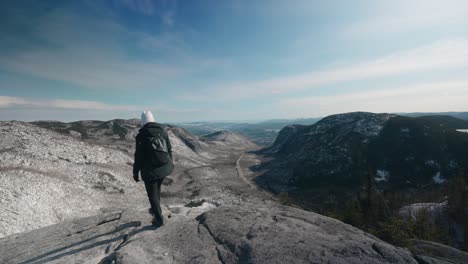 girl walking on top overlooking view of mont du dome mountain in quebec, canada on a sunny day of winter - wide shot