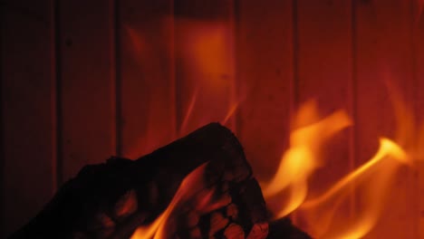 llama ardiente en la chimenea en troncos de madera