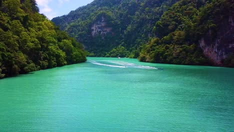 turquoise blue sea surrounded by a set of paradise islands in a sunny day with speed boat