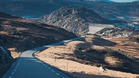 A-narrow-road-winds-through-the-autumn-tundra-valley