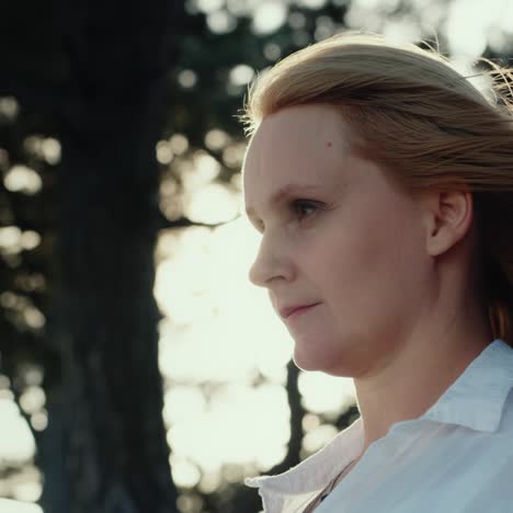 portrait of a woman in a pine forest with the wind blowing into her hair