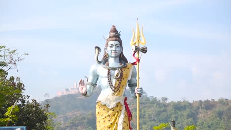 Static-shot-of-Giant-Statue-of-Hindu-God-Lord-Shiva-looking-over-the-Ganga-Ghats-at-Haridwar,Uttarakhand,-India