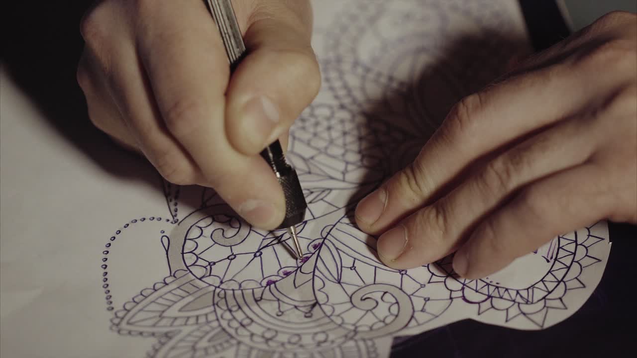 L'artista del tatuaggio che lavora su un disegno