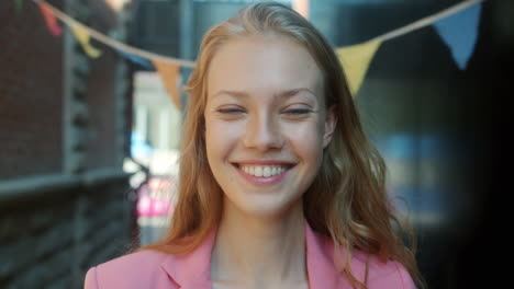 una mujer sonriente con una chaqueta rosa.