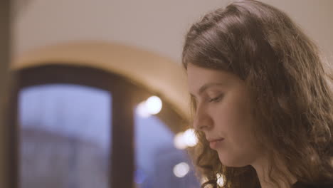 close up of curly woman playing piano