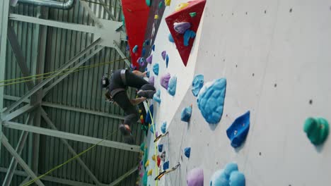 woman rock climbing on indoor climbing wall