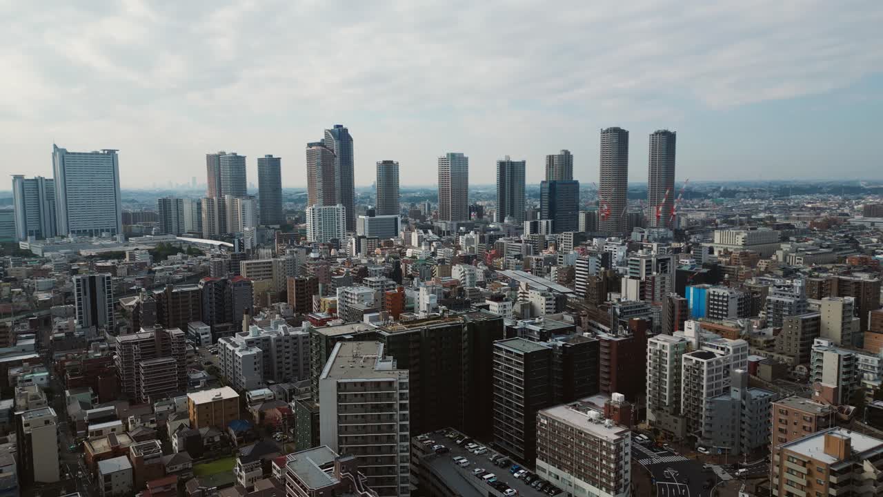 Drone pulls back over Musashi Kosugi showing skyline of Japan trade integration
