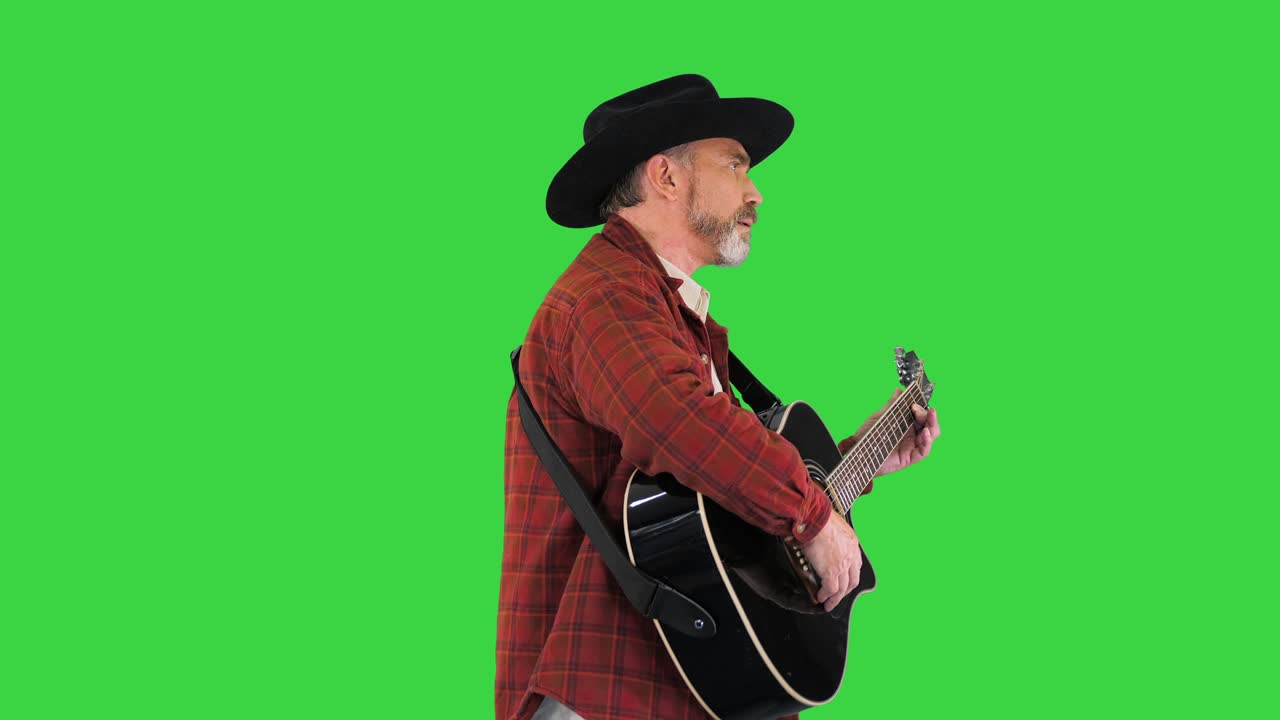 Uomo con cappello da cowboy che cammina e suona la chitarra su schermo verde, Chroma Key