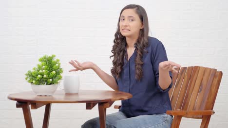 Confused-Indian-girl-sitting-in-cafe