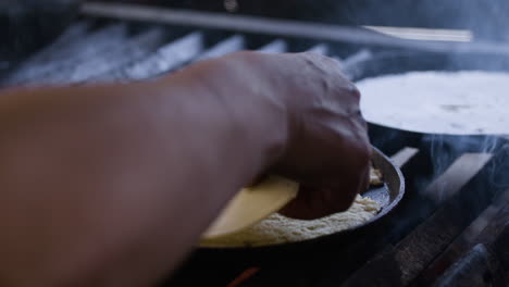 person putting cheese on tortilla