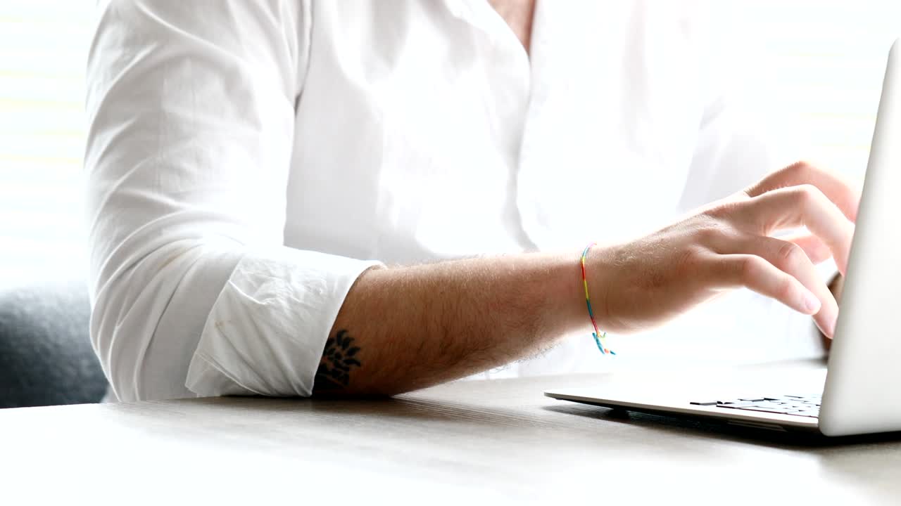 hombre de cuello blanco barbudo escribiendo y luego mirando afuera