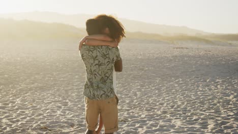 african american couple hugging at beach