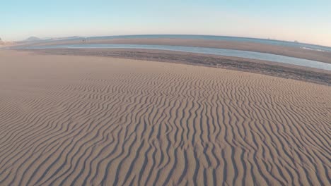 Parallele-Linien-Im-Sand,-Die-Sich-Ihren-Weg-Zum-Pazifischen-Ozean-Schlängeln